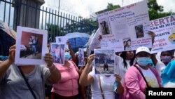 Manifestantes sostienen carteles durante una protesta para exigir la liberación de sus familiares que fueron detenidos durante el estado de emergencia para frenar la violencia de las pandillas, en San Salvador, El Salvador, el 26 de julio de 2022. REUTERS/Jessica Orellana