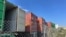 FILE - Containers stored on a lot are seen among warehouses in Fontana, California, July 17, 2022.