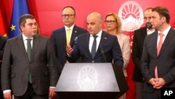 North Macedonia's Prime Minister Dimitar Kovacevski, center, speaks to the media with Vice Prime Minister Began Maricic, left, Foreign Minister Bujar Osmani, right and other Cabinet ministers in Skopje, North Macedonia, July 16, 2022.