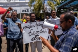스리랑카 무역협회 대표들과 활동가들이 18일 수도 콜롬보 시내에서 라닐 위크레메싱게 대통령 권한대행 반대 시위를 벌이고 있다.