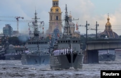 Russian warships, including minesweepers ships Pavel Khenov and Alexander Obukhov, sail during a parade marking Navy Day in St. Petersburg, Russia, July 31, 2022.