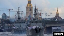 FILE: Russian warships, including minesweepers ships Pavel Khenov and Alexander Obukhov, sail during a parade marking Navy Day in St. Petersburg, Russia, July 31, 2022.