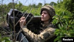 Seorang tentara Ukraina memegang senjata anti-tank ringan generasi berikutnya (NLAW) di posisi garis depan, di tengah serangan Rusia di Ukraina, dekat Bakhmut, wilayah Donbas Ukraina 5 Juni 2022. (Foto: REUTERS/Gleb Garanich)