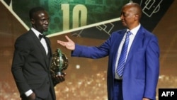L'attaquant sénégalais Sadio Mané (à g.) reçoit avec le Ballon d'or masculin des mains du président de la CAF Patrice Motsepe, le 21 juillet 2022, à Rabat, au Maroc.