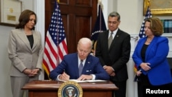 FILE - President Joe Biden signs an executive order to help safeguard women's access to abortion and contraception, as Vice President Kamala Harris, Health and Human Services Secretary Xavier Becerra and Deputy Attorney General Lisa Monaco look on, at the White House in Washington, July 8, 2022.