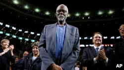 FILE - Boston Celtics legend Bill Russell stands court side during a tribute in his honor in the second quarter of an NBA basketball game against the Milwaukee Bucks in Boston, Nov. 1, 2013. Russell's family said on social media that he died on Sunday, July, 31, 2022.