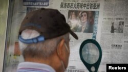 A man reads the 'Global Times' newspaper that features a front page article about US House of Representatives Speaker Nancy Pelosi's Asia tour at a street display wall in Beijing, Aug. 1, 2022. The front page headline reads: 'Pelosi visits Asia in the sme