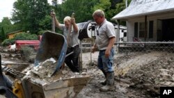 FILE - Volunteers from the local Mennonite community clean flood damaged property from a house at Ogden Hollar in Hindman, Ky., July 30, 2022. 