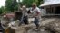 FILE - Volunteers from the local Mennonite community clean flood damaged property from a house at Ogden Hollar in Hindman, Ky., July 30, 2022. 
