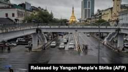 Protesters walk through a road in Yangon, Myanmar, with umbrellas bearing the number 8 in Burmese during a rally to mark the anniversary of the August 8, 1988 democracy uprising. 