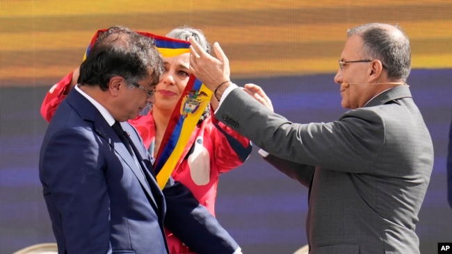 El presidente de Colombia, Gustavo Petro, recibe la banda presidencial de manos del presidente del Congreso, Roy Barreras, a la derecha, y de la senadora María José Pizarro durante su ceremonia de investidura en Bogotá, Colombia, el domingo 7 de agosto de 2022. (Foto AP/Fernando Vergara)