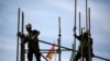 Trabajadores construyen una estructura de tubería en un andamio durante el Día Mundial de la Seguridad y la Salud en el Trabajo en la capital andaluza de Sevilla, sur de España, el 28 de abril de 2016. REUTERS/Marcelo del Pozo/Foto de archivo
