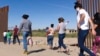 FILE - Brazilian migrants make their way around a gap in the U.S.-Mexico border in Yuma, Ariz., seeking asylum in the U.S. after crossing over from Mexico, June 8, 2021. 