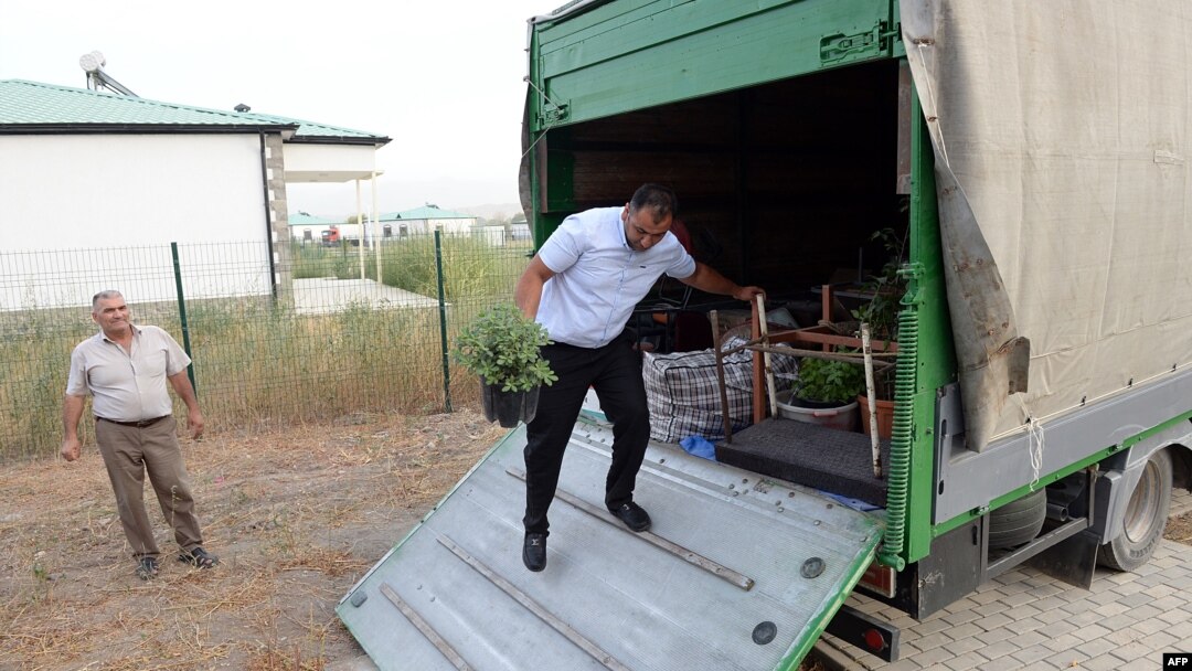 Bayram Mamedov unloads a truck with belongings as he and his family settle in their new house as they return to the newly rebuilt village of Agali in the district of Zangilan, Azerbaijan, July 19, 2022.