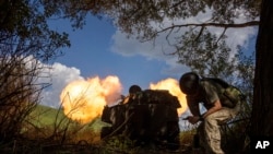 FILE - Ukrainian self-propelled artillery shoots toward Russian forces in the Kharkiv region, Ukraine, July 27, 2022.