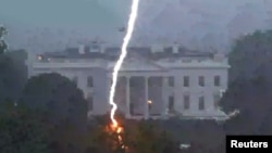 A lightning strike hits a tree in Lafayette Park across from the White House during an evening thunderstorm, as seen in this frame grab from a Reuters TV video camera mounted on a nearby rooftop in Washington, Aug. 4, 2022.