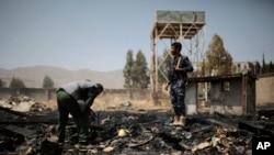 FILE - Yemeni police inspect a site hit by airstrikes in Sanaa, Yemen, March 26, 2022.