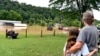 Bonnie Combs hugs her 10-year-old granddaughter Adelynn Bowling as her property becomes covered by the North Fork of the Kentucky River in Jackson, Ky., July 28, 2022. 