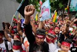 Myanmar nationals living in Thailand with a picture of deposed Myanmar leader Aung San Suu Kyi, seen at center, stage a rally outside Myanmar's embassy in Bangkok, Thailand, July 26, 2022.
