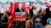 FILE - People carry banners and flags during a rally in support of Tunisian President Kais Saied in Tunis, Tunisia May 8, 2022.