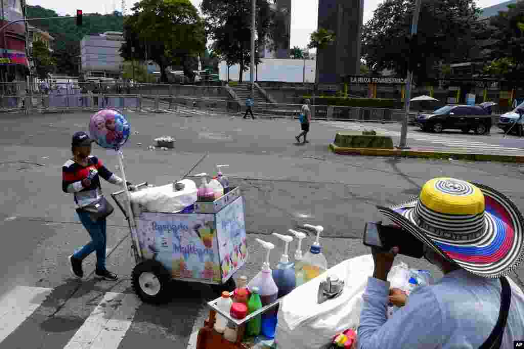 Los vendedores ambulantes se alejan mientras una huelga de maestros marcha hacia la Plaza 5 de Mayo, cerca de una barricada de seguridad instalada para bloquear el acceso a la Asamblea Nacional en la Ciudad de Panamá, el jueves 14 de julio de 2022.