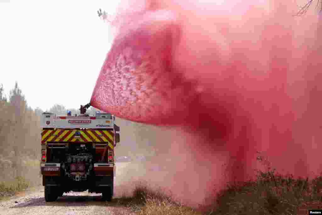 Firefighters spray flame retardant to extinguish ground fire on land in Hostens in the Gironde region of southwestern France.