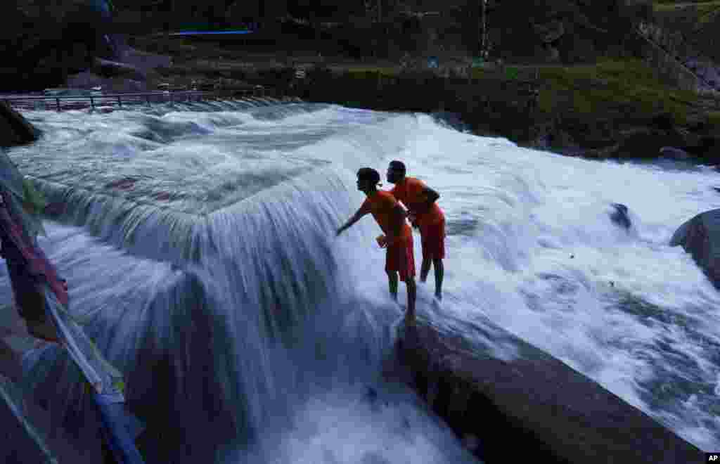 Hindu devotees collect water from the Bagmati river during the Bol Bom pilgrimage at Sudarijaal, on the outskirts of Kathmandu, Nepal.