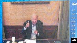 President Joe Biden gives a thumbs-up after being asked by reporters how he is feeling as he speaks virtually during a meeting with his economic team in the South Court Auditorium on the White House complex in Washington, July 22, 2022.