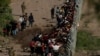 Migrantes que buscan asilo, en su mayoría de Venezuela y Cuba, son detenidos por agentes de Aduanas y Protección Fronteriza de EEUU después de cruzar el río Grande hacia suelo estadounidense desde México en Eagle Pass, Texas, el 13 de julio de 2022.