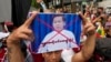 A Myanmar national living in Thailand holds a picture of Senior Gen. Min Aung Hlaing, head of the military council, while protesting outside Myanmar's embassy in Bangkok, Thailand, July 26, 2022.