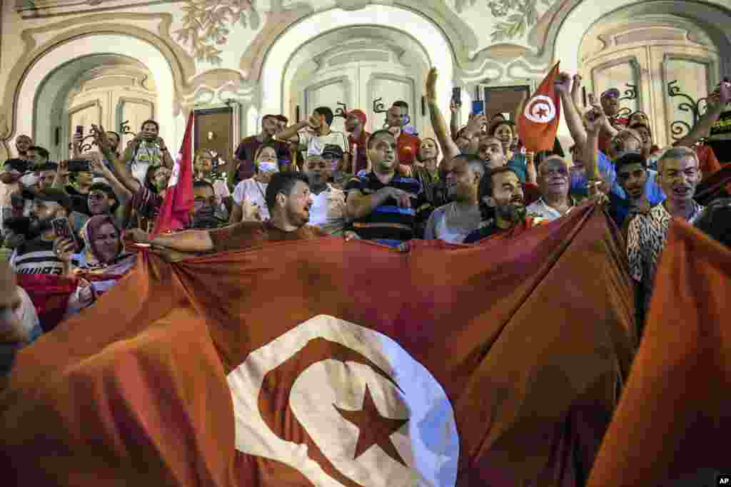 Tunisians celebrate the exit polls indicating a vote in favor of the new Constitution, in Tunis, July 25, 2022.