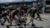 Indian policemen detain a Kashmiri Shiite Muslim for participating in a religious procession during restrictions in Srinagar, Indian controlled Kashmir, Aug. 7, 2022. 