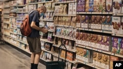 A man shops at a supermarket, July 27, 2022, in New York. The US economy shrank from April through June for a second straight quarter, contracting at a 0.9% annual pace and raising fears that the nation may be approaching a recession.