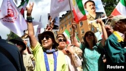 People react to the verdict of the trial of Hamid Noury, a former Iranian prosecution official accused of crimes against international law and murder in Iran in 1988, outside the Stockholm District Court in Sweden, July 14, 2022. Noury was sentenced to life in prison.