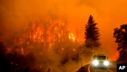 A firetruck drives along California Highway 96 as the McKinney fire burns in Klamath National Forest, Calif., July 30, 2022. 