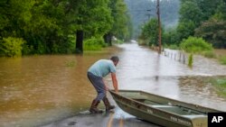 A man prepares to launch a boat near flooded Wolverine Road in Breathitt County, Kentucky, on July 28, 2022.