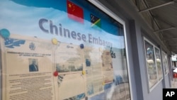 A display case of photos is seen outside the Chinese Embassy in Honiara, Solomon Islands on April 2, 2022. (AP Photo/Charley Piringi, File)