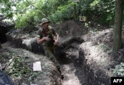 FILE - A Ukrainian serviceman walks along an entrenched position on the front line near Avdiivka, Donetsk region, on June 18, 2022, amid the Russian invasion of Ukraine.