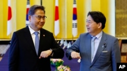 FILE - South Korean Foreign Minister Park Jin, left, and Japanese counterpart Yoshimasa Hayashi bump elbows before their talk in Tokyo, July 18, 2022. 