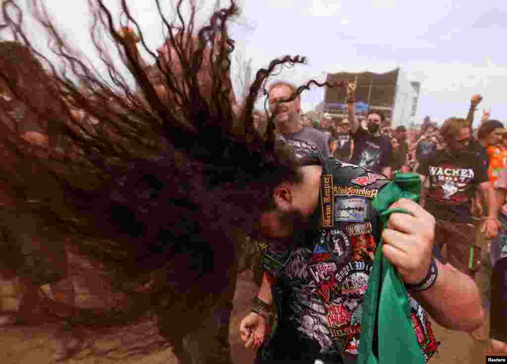 A festivalgoer does a &quot;head banging&quot; during the Wacken Open Air 2022 heavy metal festival in Wacken, Germany.