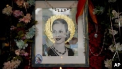 Una vela, junto a una imagen de la fallecida ex primera dama argentina María Eva Duarte de Perón, más conocida como "Evita", en el restaurante "El Santa Evita", en Buenos Aires, Argentina, el 24 de julio de 2022.