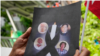 A Myanmar national living in Thailand holds the pictures of the executed political prisoners in Myanmar, as they protest outside Myanmar's embassy in Bangkok, Thailand, Tuesday, July 26, 2022. 