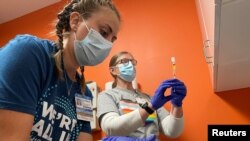 La Dra. Emily Drwiiega de la Universidad de Illinois Health y Maggie Butler, una enfermera registrada, preparan vacunas contra la viruela del mono en la clínica sin fines de lucro Test Positive Aware Network en Chicago, Illinois, EEUU, el 25 de julio de 2022.