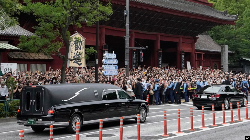 日本前首相安倍晋三的葬礼举行后，运载安倍棺木的灵车离开寺庙，日本民众路旁送行。（2022年7月12日）(photo:VOA)