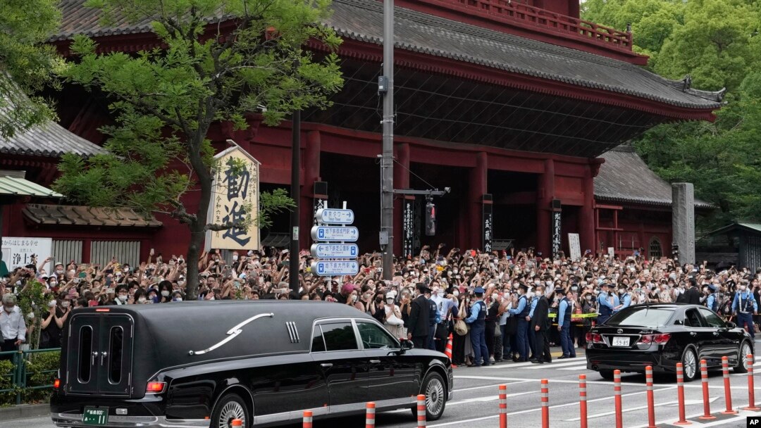Warga Jepang melepas kepergian mantan PM Shinzo Abe, saat mobil membawa jenazahnya meninggalkan kuil, 12 Juli 2022.