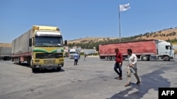 FILE - A convoy transporting humanitarian aid crosses into Syria from Turkey through the Bab al-Hawa border crossing on July 8, 2022. 