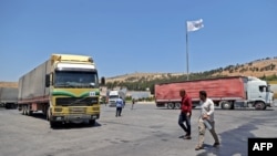 FILE - A convoy transporting humanitarian aid crosses into Syria from Turkey through the Bab al-Hawa border crossing on July 8, 2022. 