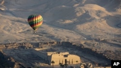 FILE -Sebuah balon udara panas terbang di atas Kuil Makam Ramsis III di Medinet Habu, Luxor, Mesir, 1 April 201. Mesir menangguhkan layanan wisata balon udara panas di atas kota kuno Luxor setelah dua wisatawan mengalami luka ringan, Senin, 18 Juli 2022. (AP/Amr Nabil)