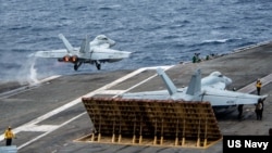美国海军公布的这张拍摄于南中国海的照片显示，F/A-18F超级大黄蜂战斗机在“里根号”航母上起飞。(2022年7月13日)