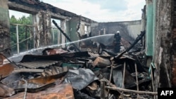 A firefighter extinguishes a blaze in the building of a vocational school in the Ukrainian city of Kharkiv after a missile strike on July 30, 2022.